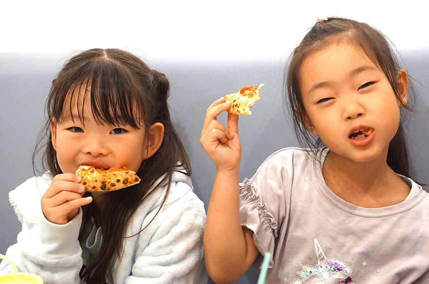 ラクイラドォーロでピザを食べる子ども