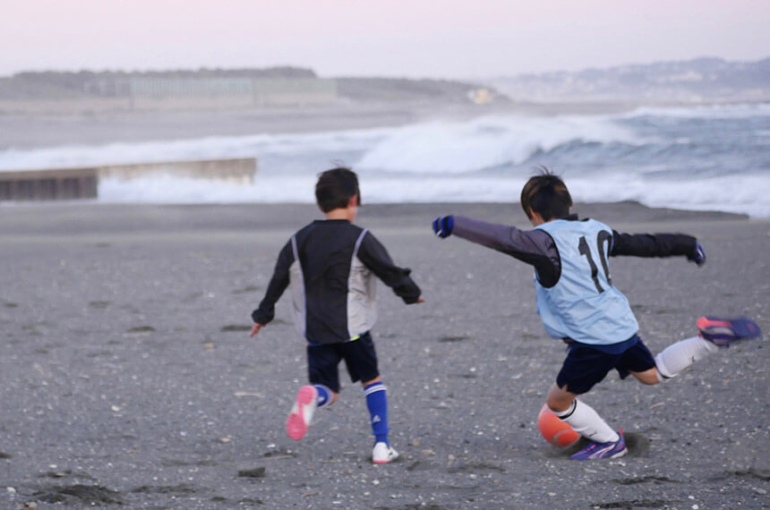 ビーチサッカーをする子ども