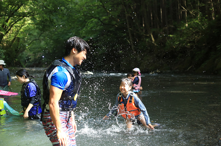キャンプで川遊びをする子ども
